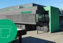 SÜDPACK Boosts Flexographic Printing Capabilities Exterior of a packaging factory with a 'SUOPACK' sign and a large green circular overlay containing a white printer icon.